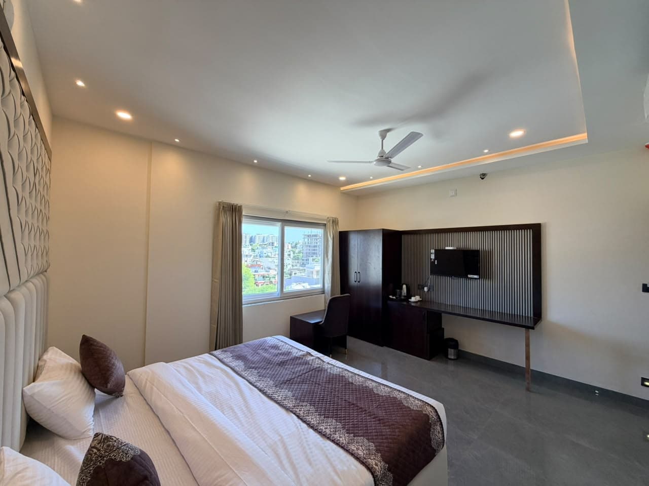 Wide view of Brick Comfort Room with work desk and television