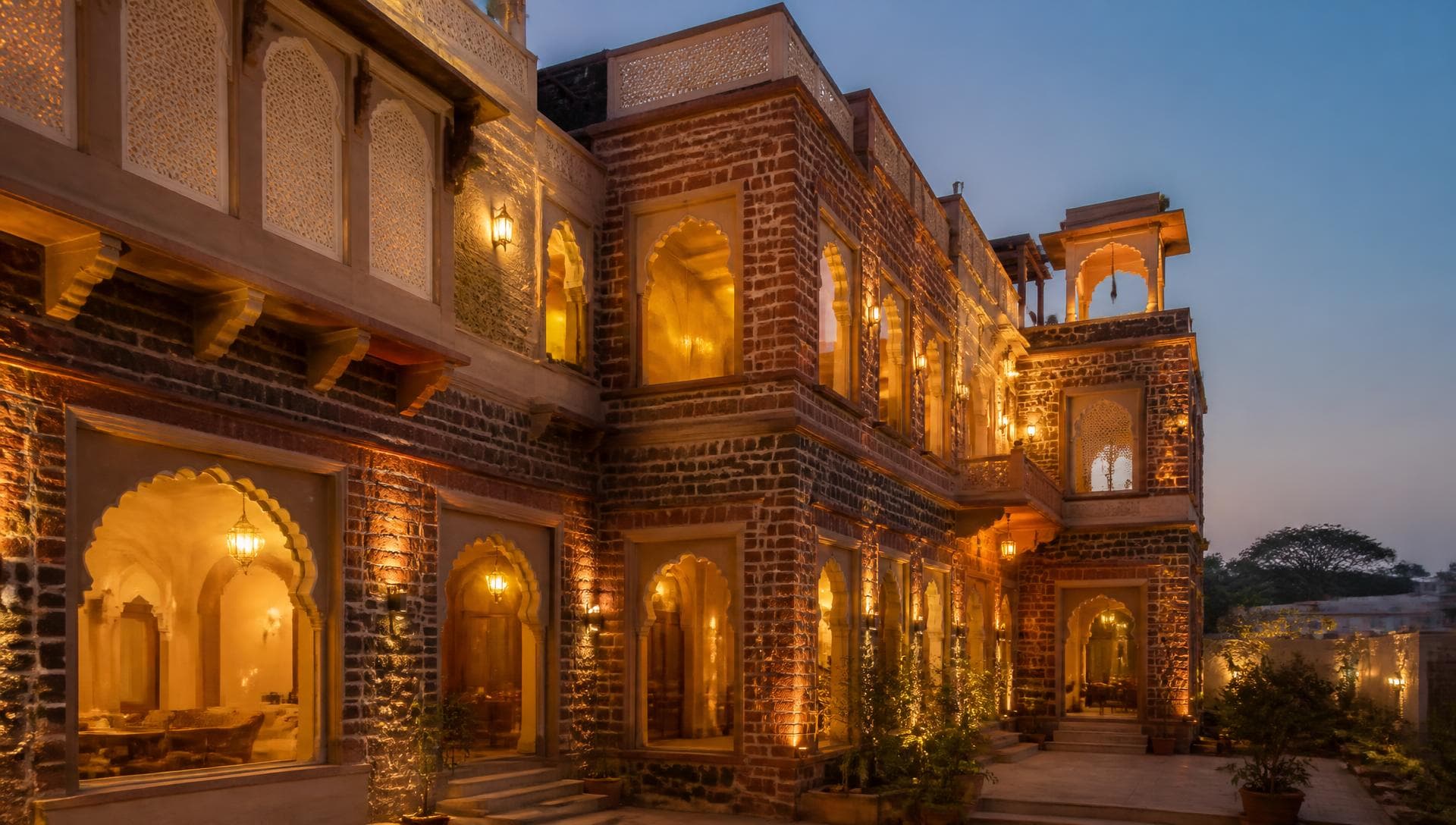 Evening view of the brick and basalt facade of the hotel in Udaipur